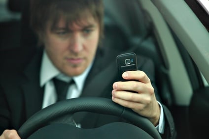 A man texting while driving.