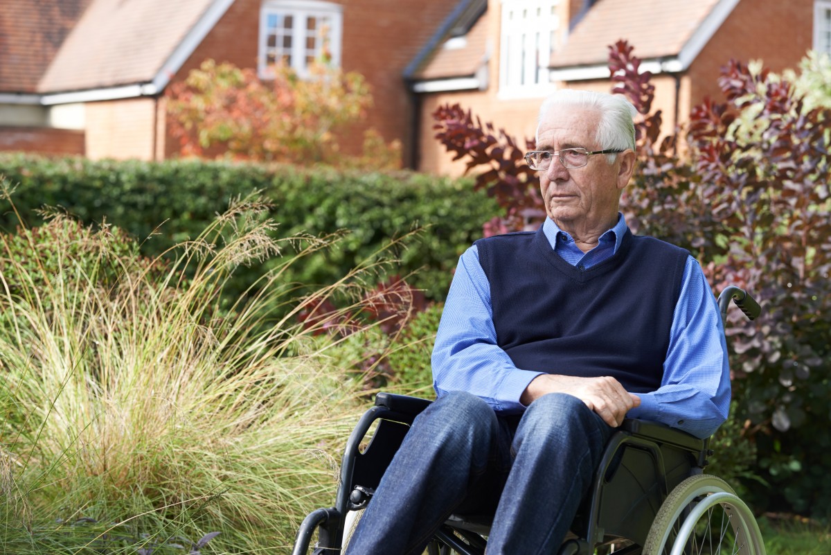 An elderly man in his wheelchair outside