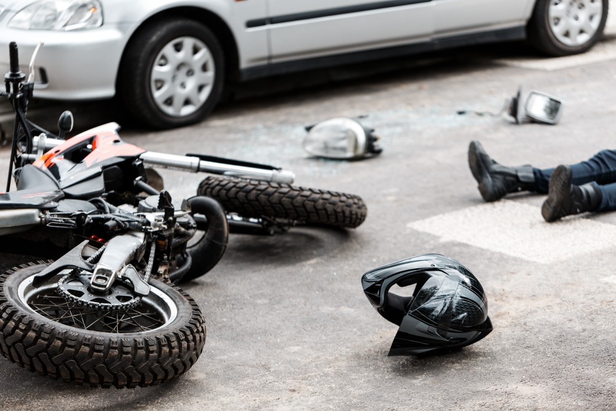 someone laying on the ground after they were hit while riding their motorcycle
