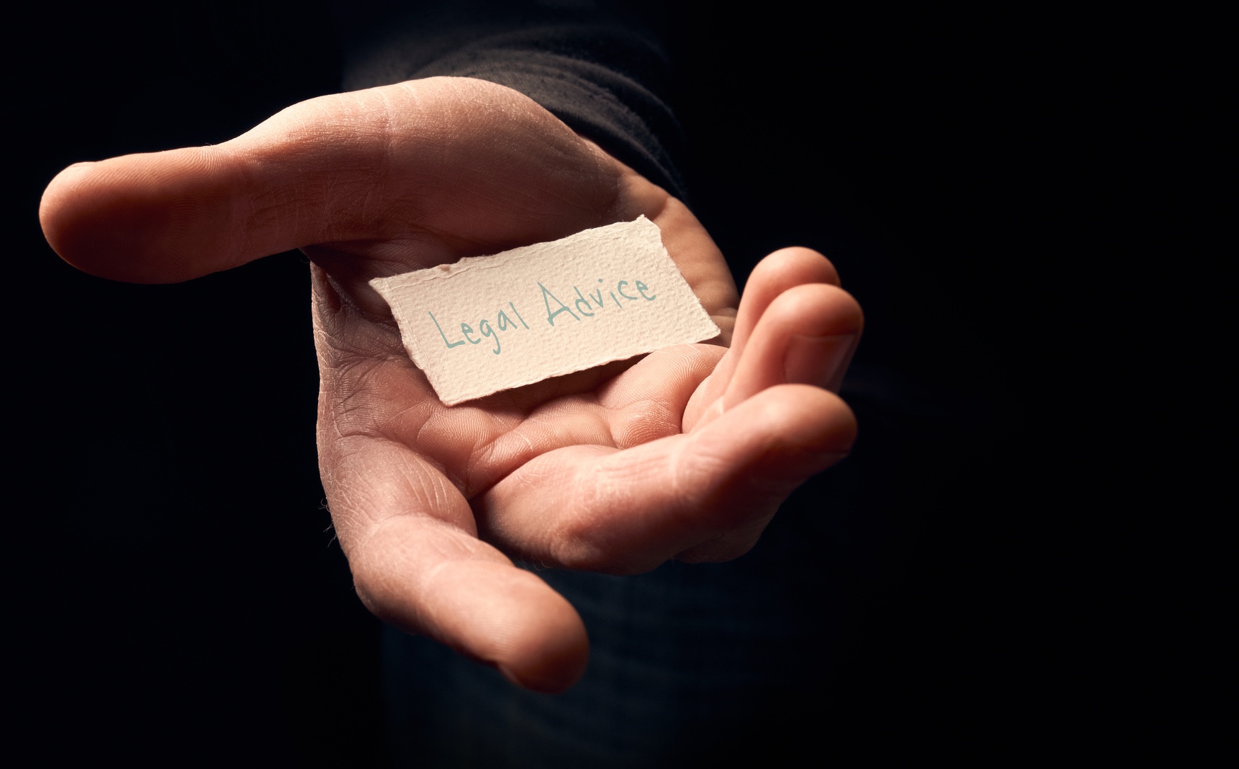 Fotolia_85249261_Subscription_Monthly_M someone holding a card that reads "legal advice" out for someone