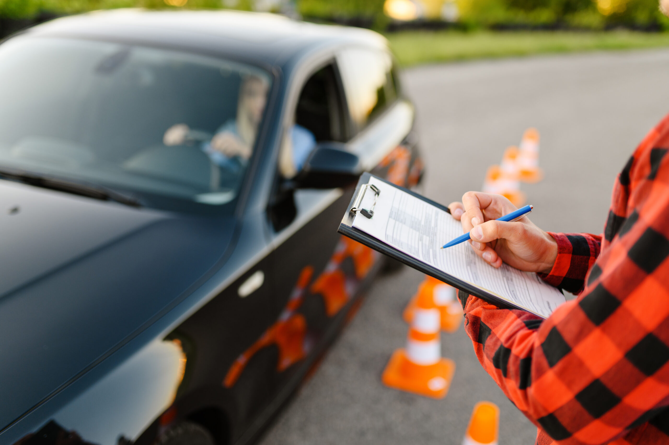 Instructor with checklist and woman in car for learners permit exam