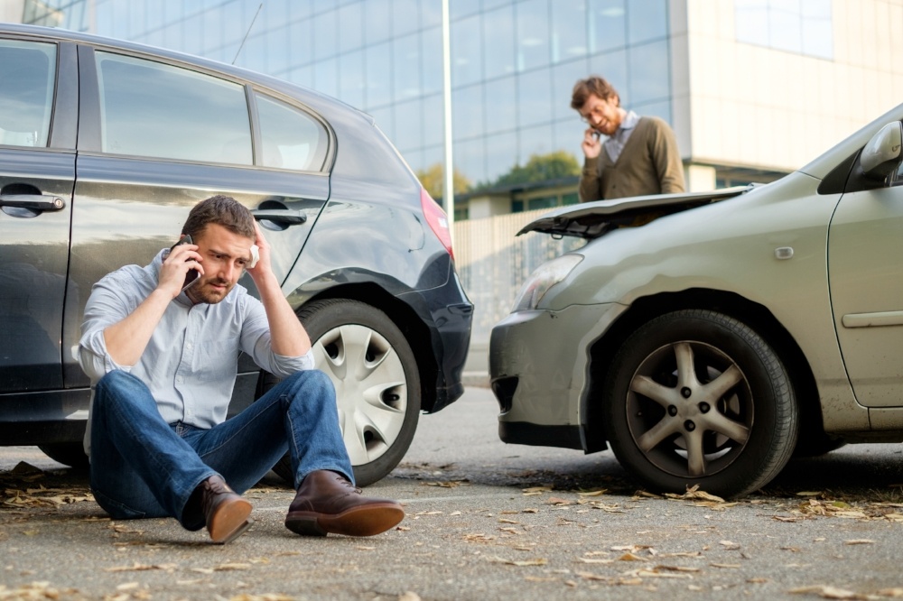 two people making a phone call after being involved in a car accident