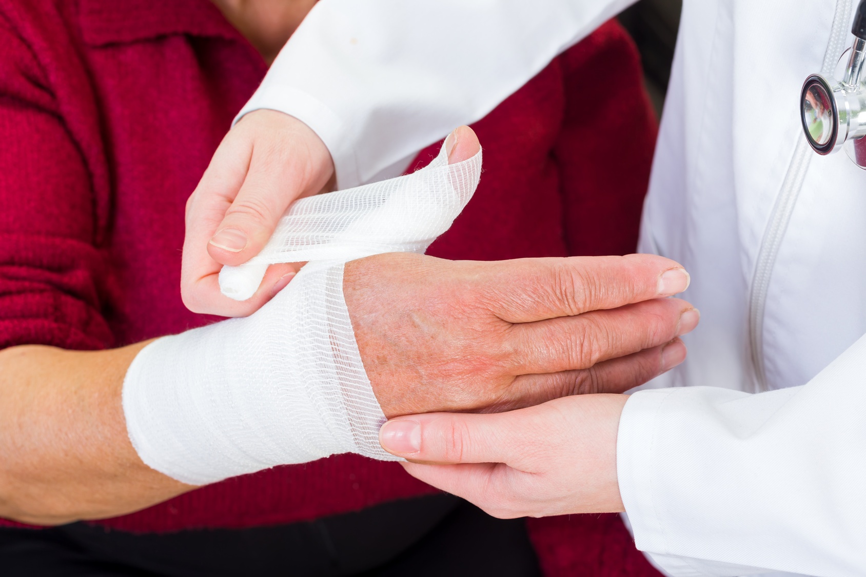 Old_man_getting_hand_bandaged_by_physician A doctor bandaging a hand wound.