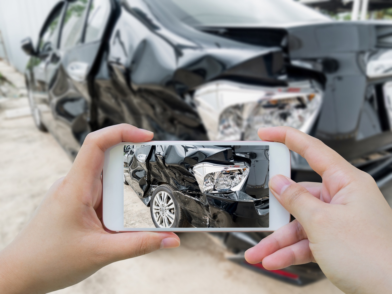 Uninsured_Motorist_Accident_Statistics Someone taking a picture of the damage done to their car after an accident