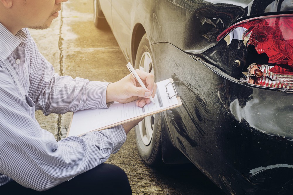 Insurance adjuster taking notes at an accident