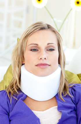 Attractive woman wearing neckbrace lying on a sofa woman wearing neckbrace lying on a sofa against a white background