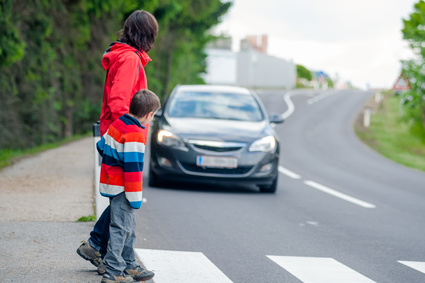 Car stopped for pedestrian Mother and son passing a street when a car coming