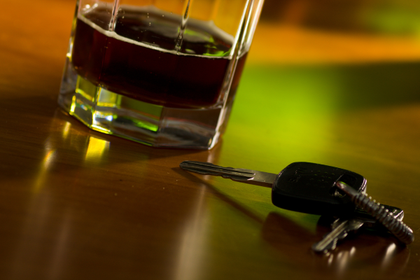 Car keys on a bar with a glass of whiskey