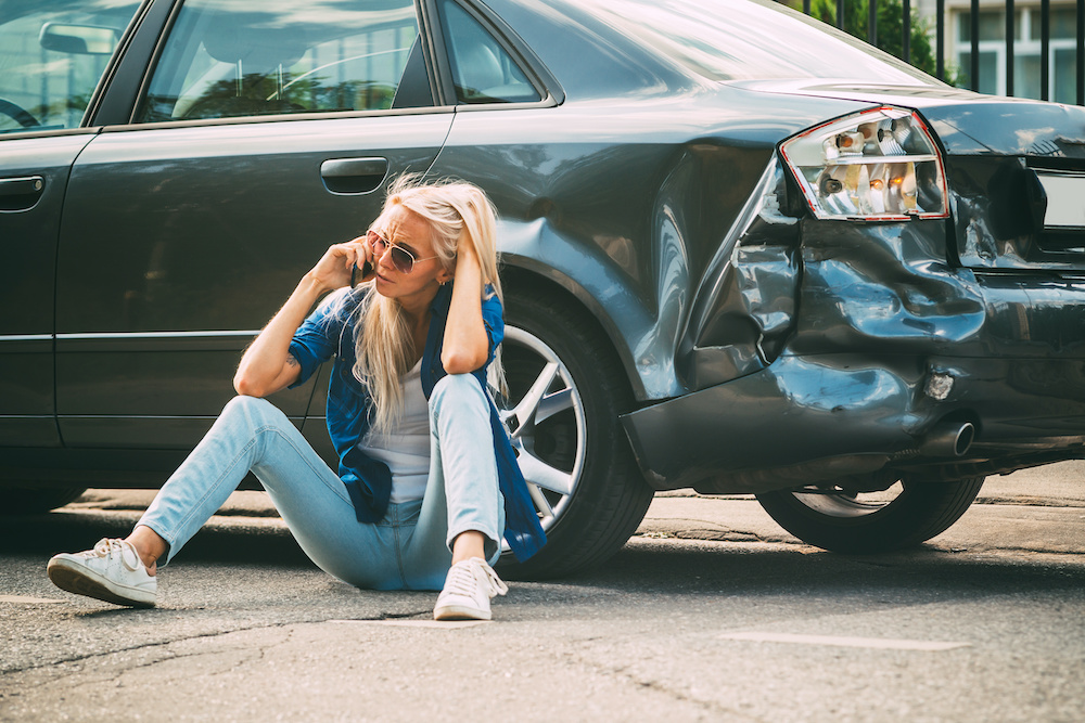 hit%20and%20run_251454282 someone sitting by their car, on the phone, after an accident