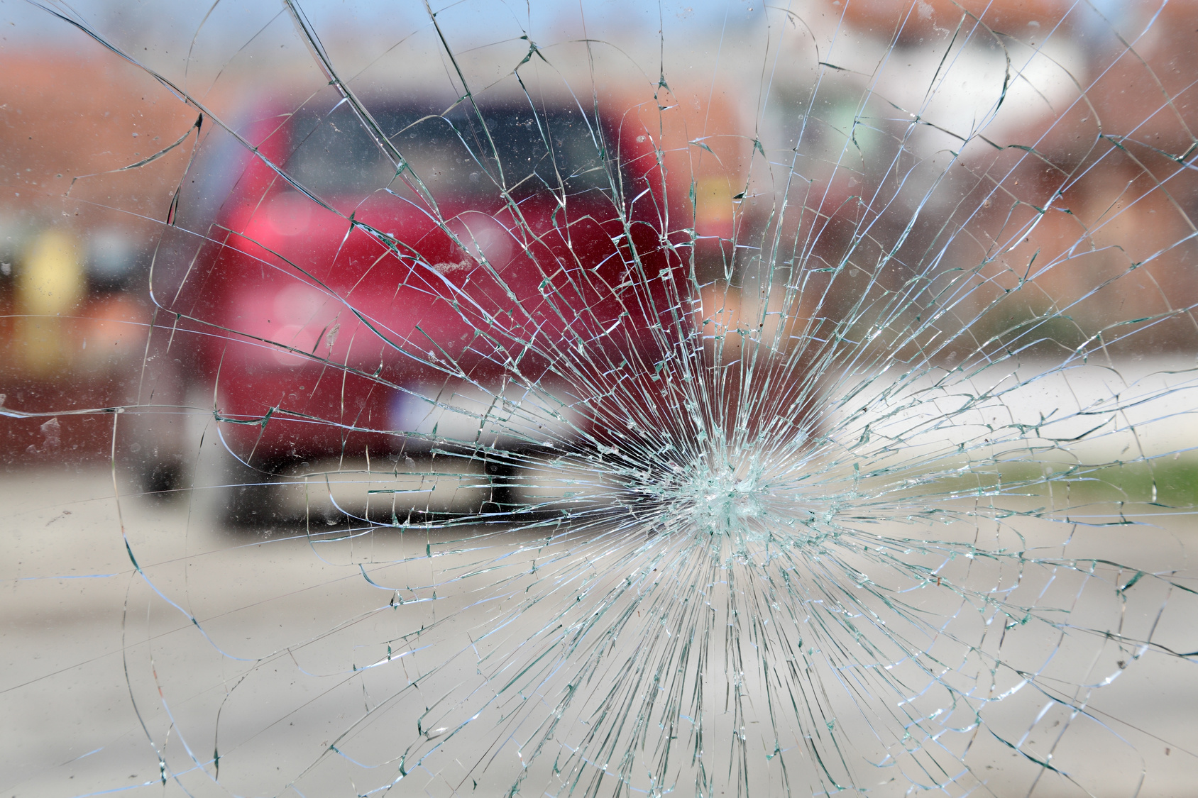 Broken windshield, car accident Broken windshield with red car in background