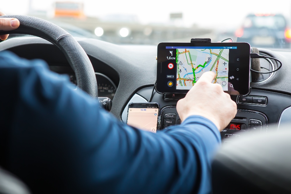 An uber driver distracted by his phone map
