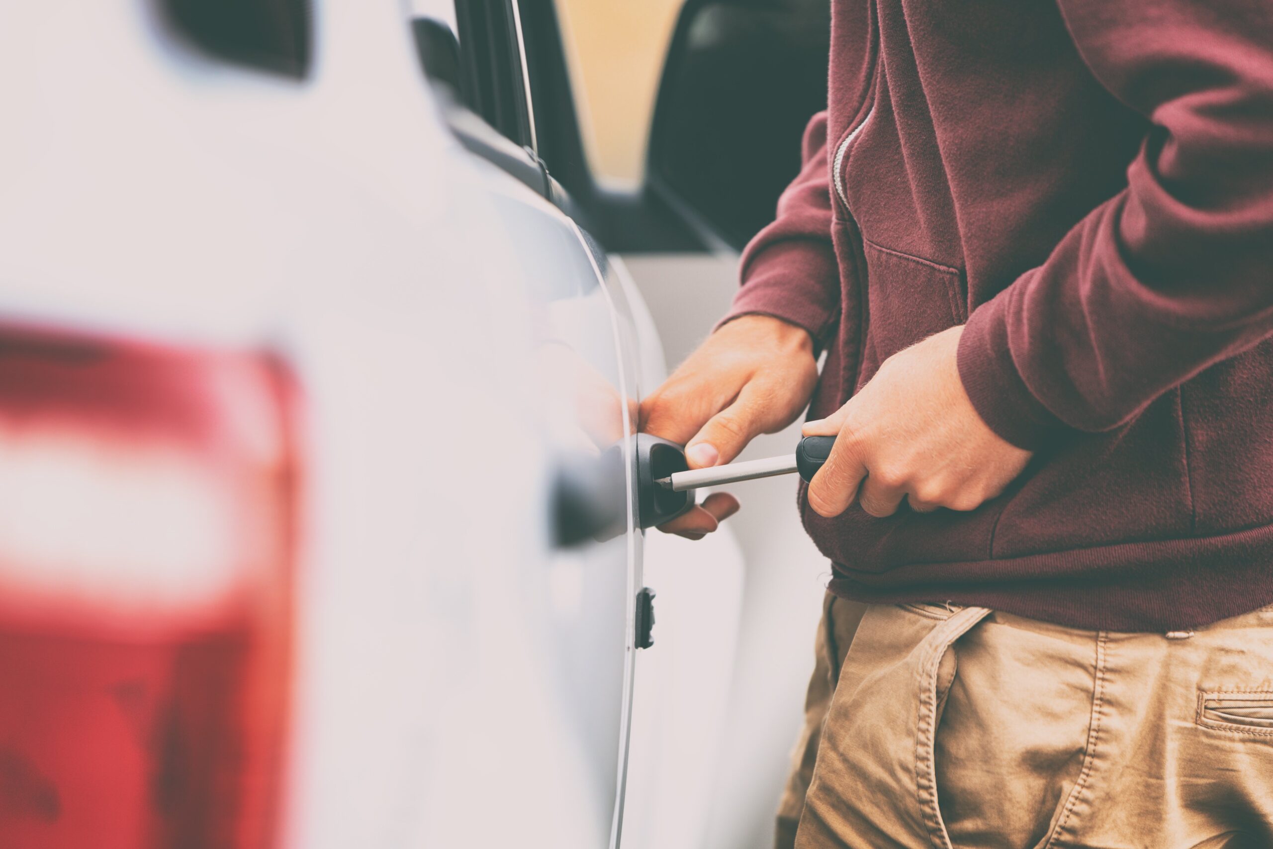 man stealing vehicle with screwdriver