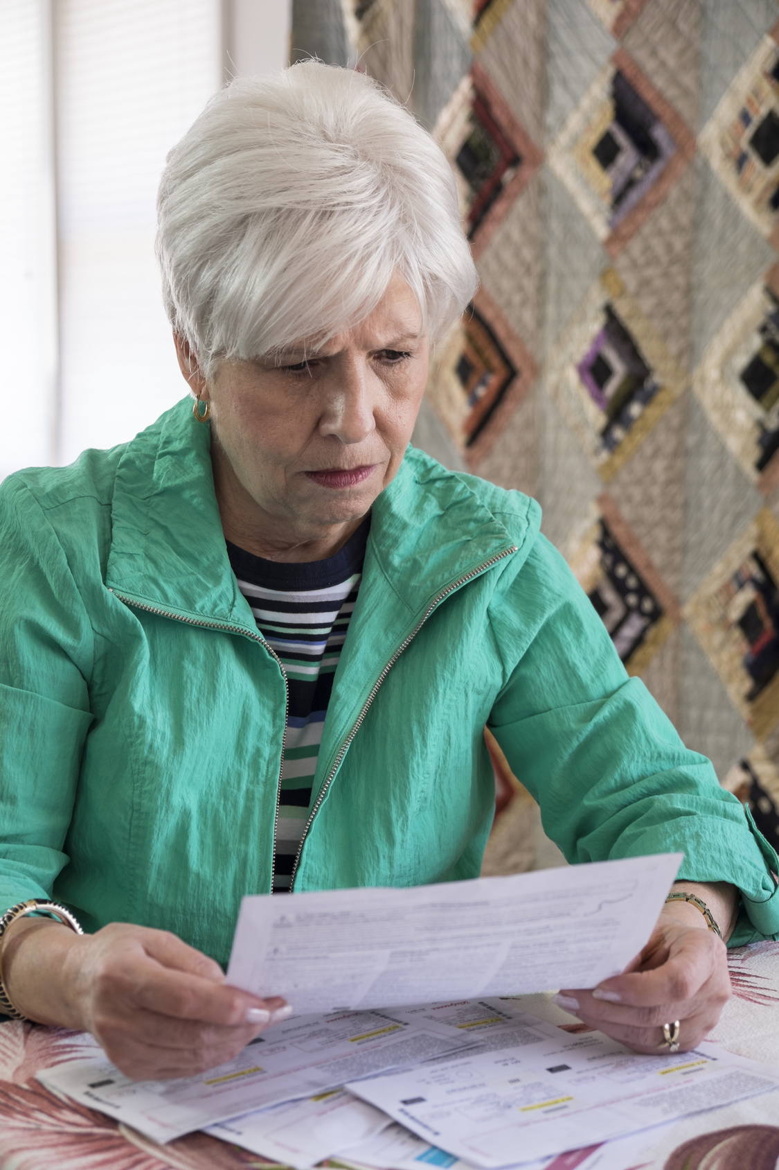 A mature woman looking over medical bills