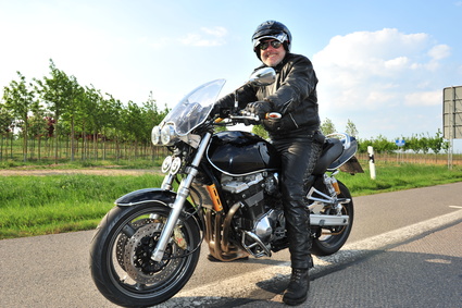 Biker lachend auf Motorrad Man in leather cycling gear riding his motorcycle