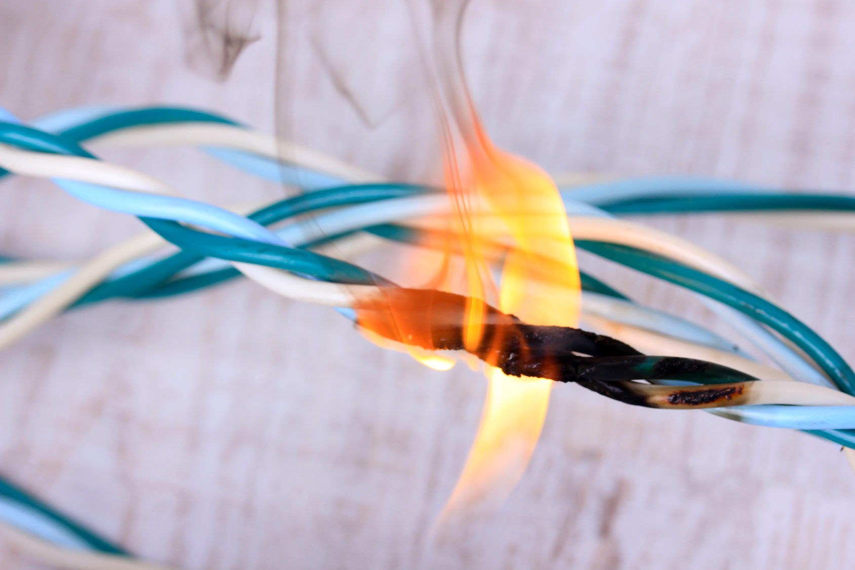 Short circuit, burnt cable, on color wooden background Short circuit, burnt cable, on color wooden background