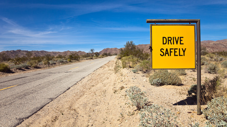 Drive Safely Sign in the Sonora Desert A sign on a desert road that reads "drive safely"