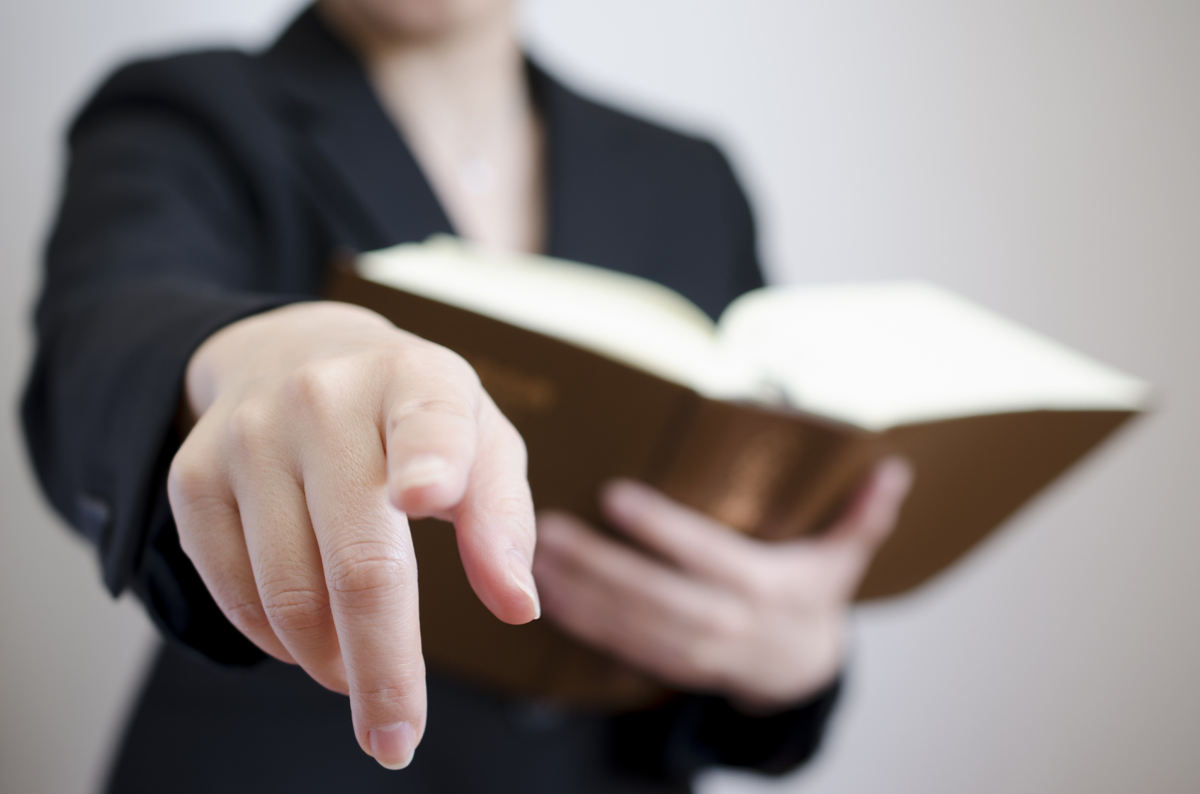 女性弁護士 A woman holding a book and pointing seductively at the camera