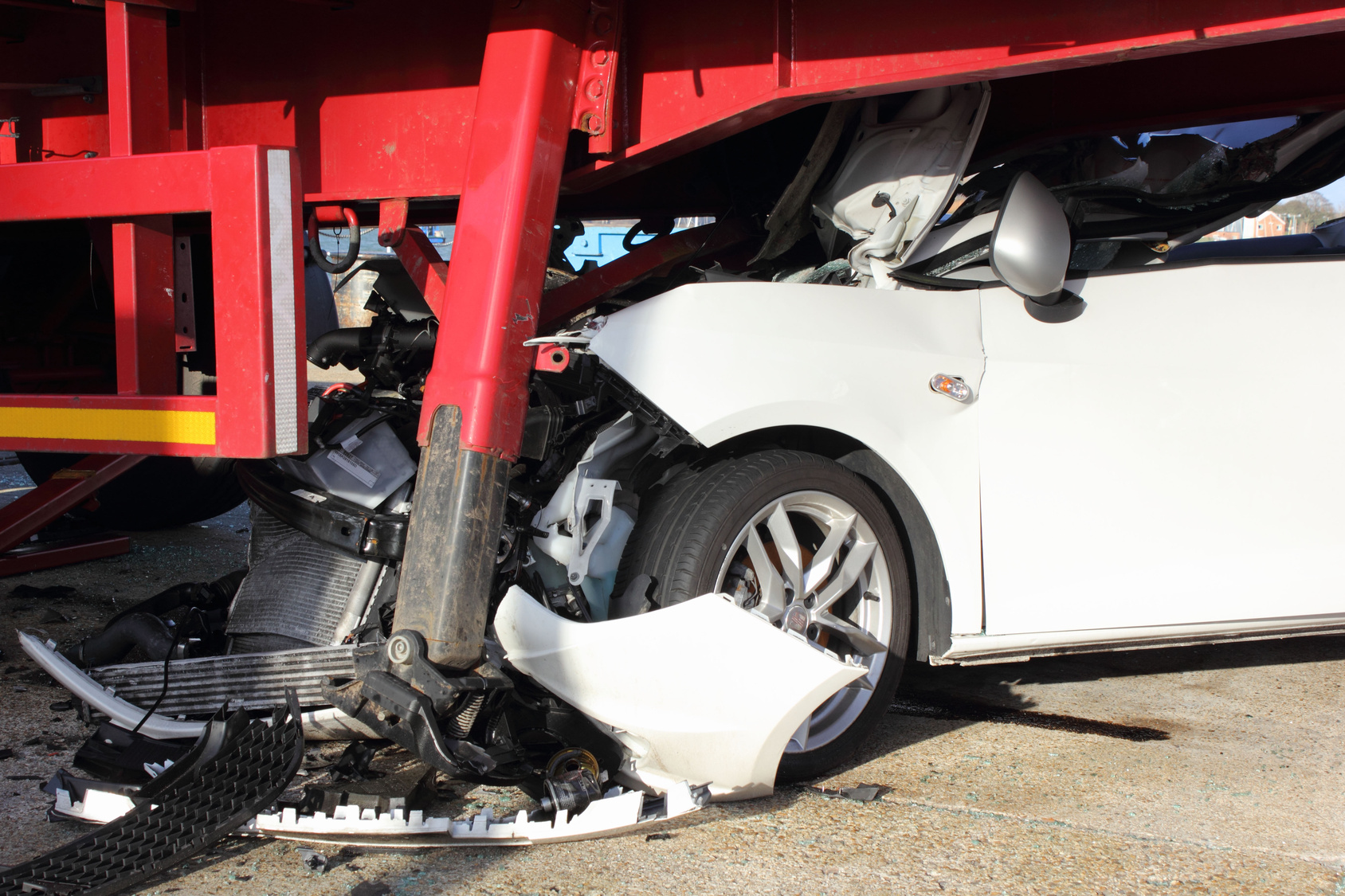 A car that has crashed into a lorry trailer causing much damage A car that has crashed into a lorry trailer causing much damage