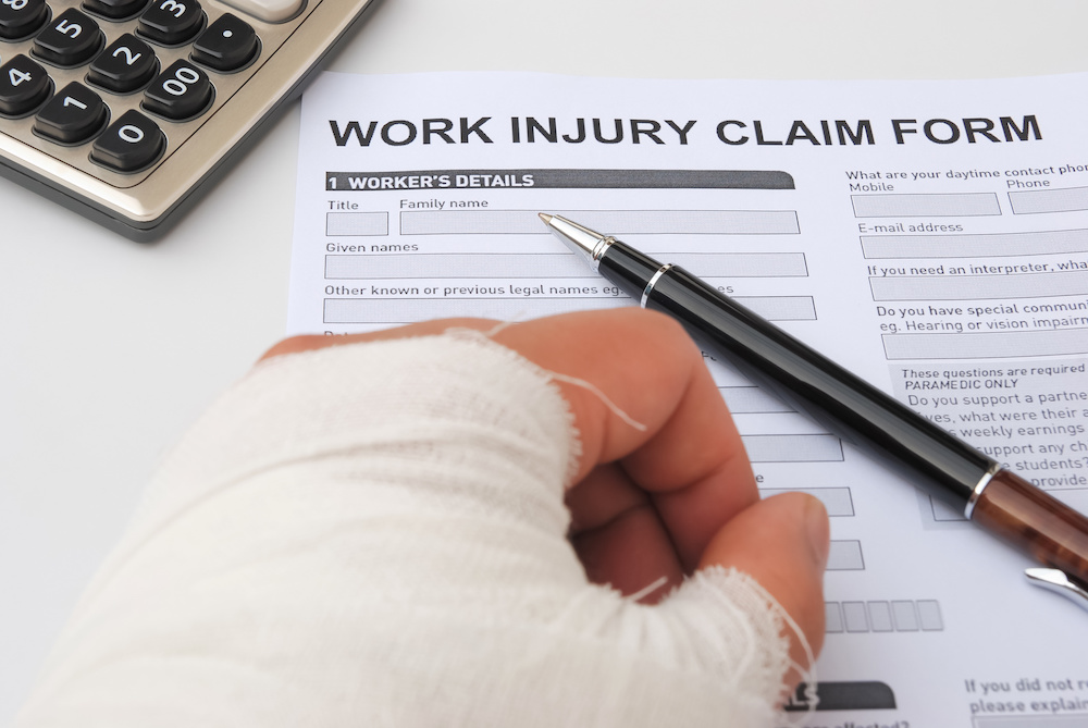 Someone filling out a work injury claim form