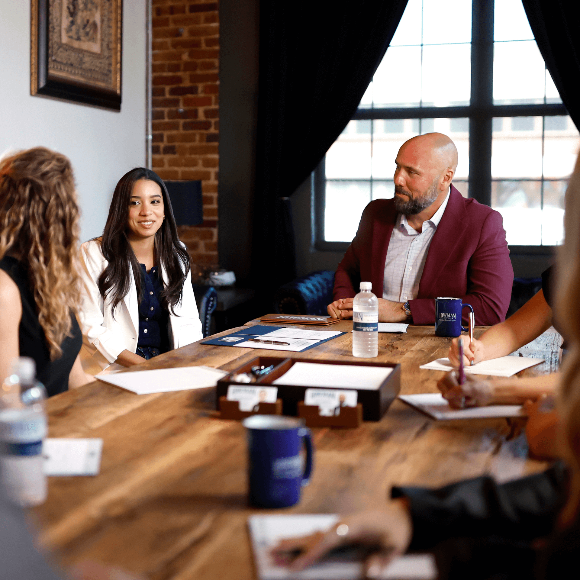 Lowman law firm team meeting at a large wooden table.